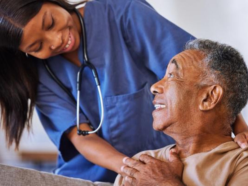 A caregiver smiling warmly with an older man